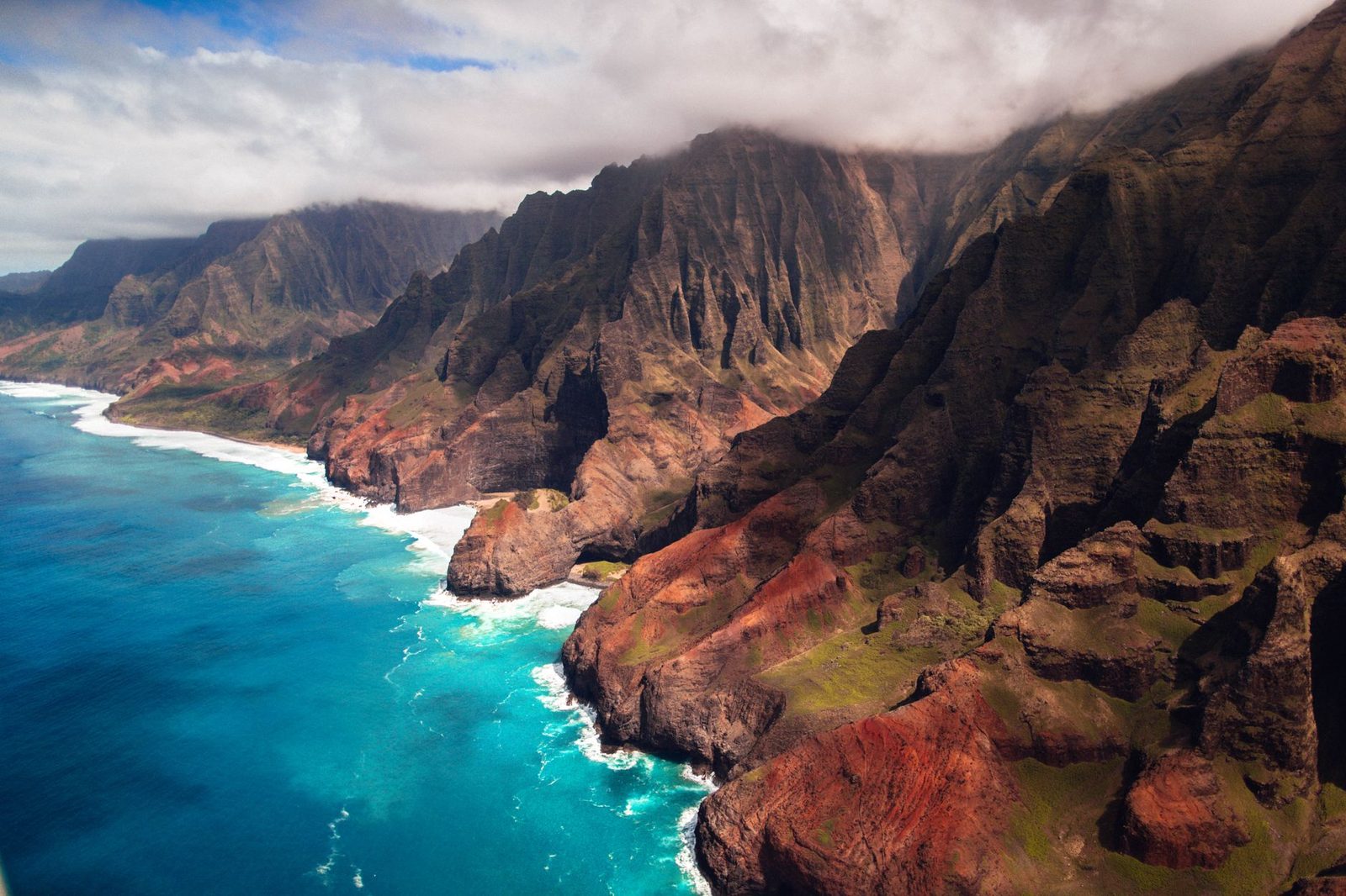 The fluted cliffs of the Nā Pali Coast dropping into turquoise water, Kauaʻi